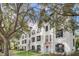 Charming white townhomes with black shutters and red tile roofs nestled among mature trees at 234 N Glenwood Ave # 4, Orlando, FL 32803
