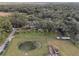 An aerial view of the property with a pond, trees, and a fenced area at 502 N Noel Ct, Chuluota, FL 32766