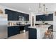 Modern kitchen featuring sleek navy cabinets, stainless steel appliances, and an island at 5040 Oak Seed Way, St Cloud, FL 34771
