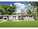 Charming single-story home with a yellow door, carport, and landscaped front yard at 6510 Corona Dr, Orlando, FL 32810