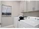 Laundry room with washer, dryer, and overhead cabinets at 6944 Rosy Sky Ave, Orlando, FL 32829