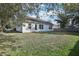 Backyard view highlighting the grassy lawn and a fenced perimeter with trees at 1004 Puget Ln, Kissimmee, FL 34759