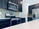 Modern kitchen with stainless steel appliances, dark cabinets, and white countertops at 15271 Willow Arbor Cir, Orlando, FL 32824