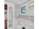 Updated bathroom with white vanity and glass-paned door at 1550 Indiana Ave, Winter Park, FL 32789
