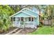 Quaint light blue house with a white porch and lush green lawn at 1550 Indiana Ave, Winter Park, FL 32789