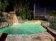 Inviting pool with waterfall feature at night at 2904 S Peninsula Dr, Daytona Beach Shores, FL 32118