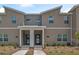 Modern two-story townhome with a gray and white facade, landscaped front yard, and paved walkway at 2949 Penelope Loop, Kissimmee, FL 34746