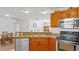 Kitchen with wood cabinets, stainless steel appliances, and a view of the dining area at 3891 Sw 130Th Loop, Ocala, FL 34473