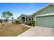Paved driveway leading to a green one-story home with attached garage at 5761 Woodruff Way, Lakeland, FL 33812