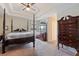 Main bedroom with four-poster bed, matching dresser, and carpeted floor at 5761 Woodruff Way, Lakeland, FL 33812