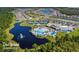 Aerial view of the community showcasing the pool, tennis courts, and lake at 6535 Shimmering Shores Ln, St Cloud, FL 34771