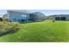 Large grassy backyard with a covered patio and view of neighboring homes at 6535 Shimmering Shores Ln, St Cloud, FL 34771
