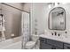 Bathroom with tiled shower and tub combination, vanity, and arched mirror at 6535 Shimmering Shores Ln, St Cloud, FL 34771
