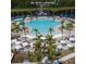 Resort-style community pool with ample seating, umbrellas, and palm trees at 6535 Shimmering Shores Ln, St Cloud, FL 34771
