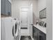 Laundry room with front-loading washer and dryer, ample counter space, and stylish gray cabinets at 6535 Shimmering Shores Ln, Saint Cloud, FL 34771