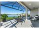 Covered patio with outdoor dining area, comfortable seating, and serene water views at 6535 Shimmering Shores Ln, St Cloud, FL 34771