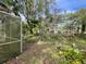 Backyard with screened enclosure, plants, and trees at 826 Rosalia Dr, Sanford, FL 32771