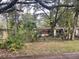 Front exterior of home with trees, landscaping, and a chain link fence at 826 Rosalia Dr, Sanford, FL 32771