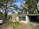 Exterior view of a single-story home with a carport, chimney, and landscaping at 826 Rosalia Dr, Sanford, FL 32771
