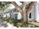 Charming brick exterior with black shutters and a large tree in front at 143 Lewfield Cir # 143, Winter Park, FL 32792