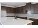 Spacious kitchen featuring an island with sink, dark cabinets, and modern backsplash at 14568 Crestavista Ave, Clermont, FL 34714