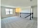 Spacious loft area with carpet, large window, and a black railing at 14568 Crestavista Ave, Clermont, FL 34714