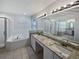 Bathroom featuring double sinks, granite countertop, soaking tub and shower at 148 Harwood Cir, Kissimmee, FL 34744