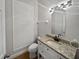 Half bathroom with granite countertop, white vanity, and modern fixtures at 148 Harwood Cir, Kissimmee, FL 34744