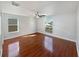 Spacious bedroom with wood-look flooring, white walls, and ceiling fan at 148 Harwood Cir, Kissimmee, FL 34744