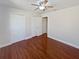 Bedroom with wood-look flooring, white walls, ceiling fan, and two closets at 148 Harwood Cir, Kissimmee, FL 34744