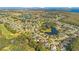 Aerial view of a residential neighborhood with houses and streets by a golf course, lake, and marsh at 1942 Willow Wood Dr, Kissimmee, FL 34746