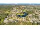 Aerial view of a residential community with houses, streets, trees, a lake, and a golf course at 1942 Willow Wood Dr, Kissimmee, FL 34746