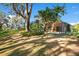 Backyard with mature trees, landscaping, and a screened lanai at 1942 Willow Wood Dr, Kissimmee, FL 34746