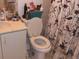 Bathroom with white toilet and vanity, and bird-patterned shower curtain at 2536 Woodgate Blvd # 201, Orlando, FL 32822