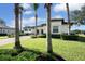 Front exterior showcasing the home's architecture, lush landscaping, and palm trees at 25459 Hawks Run Ln, Sorrento, FL 32776