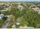 Aerial view of a house with trees, neighboring properties, and a distant cityscape at 3109 Williams St, Orlando, FL 32806