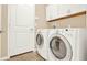 Laundry room with washer, dryer, and upper cabinets at 440 Alcove Dr, Groveland, FL 34736