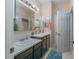 Bathroom with double vanity, teal cabinets, and large mirror at 4902 Soft Rush St, Orlando, FL 32811