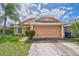 Tan house with a two-car garage and palm trees at 6554 Meritmoor Cir, Orlando, FL 32818