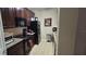 Kitchen with dark wood cabinets, black appliances, and tile floor at 8252 Civita Dr # 201, Davenport, FL 33896