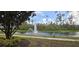Community pond with fountain, walking path, and lush greenery at 8252 Civita Dr # 201, Davenport, FL 33896