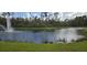 Scenic pond with fountain and green grass along the shore at 8252 Civita Dr # 201, Davenport, FL 33896