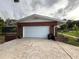 View of attached garage with white garage door and some brick landscaping at 904 Red Bird Ln, Altamonte Springs, FL 32701