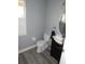 Bathroom with gray wood-look tile, white toilet, and dark vanity at 915 Ekana Green Ct, Oviedo, FL 32765