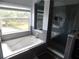 Modern bathroom with a jetted tub, glass shower, and tiled walls at 915 Ekana Green Ct, Oviedo, FL 32765