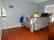 Bedroom with wood-look floors, metal bed frame, and personal items at 915 Ekana Green Ct, Oviedo, FL 32765