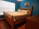 A cozy bedroom with wooden floors, large bed, and blue accent wall at 915 Ekana Green Ct, Oviedo, FL 32765