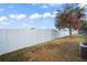 Backyard with a white vinyl fence, AC unit, and a flowering tree at 10421 Andover Point Cir, Orlando, FL 32825