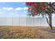 White vinyl fence and a flowering tree in a backyard at 10421 Andover Point Cir, Orlando, FL 32825