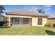 Backyard with screened patio, green lawn, and a yellow stucco exterior at 11840 Eagle Ray Lane, Orlando, FL 32827